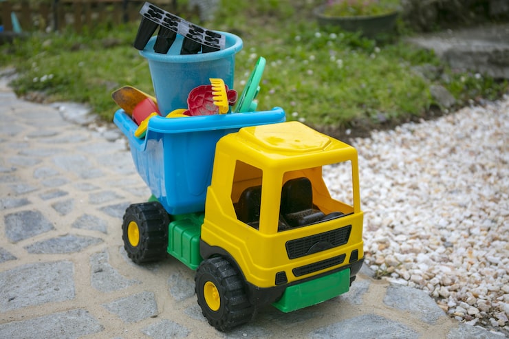 Foto grátis caminhão de brinquedo amarelo no quintal