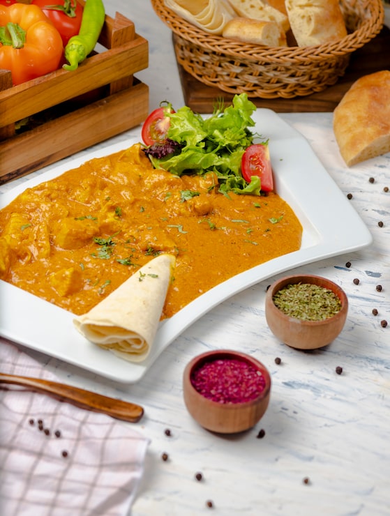 Foto grátis caril indiano com peito de frango e molho de tomate servido com lavash.