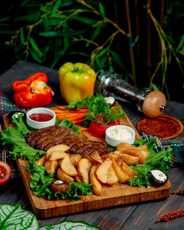 Foto grátis carne frita e batatas em casa em uma placa de madeira