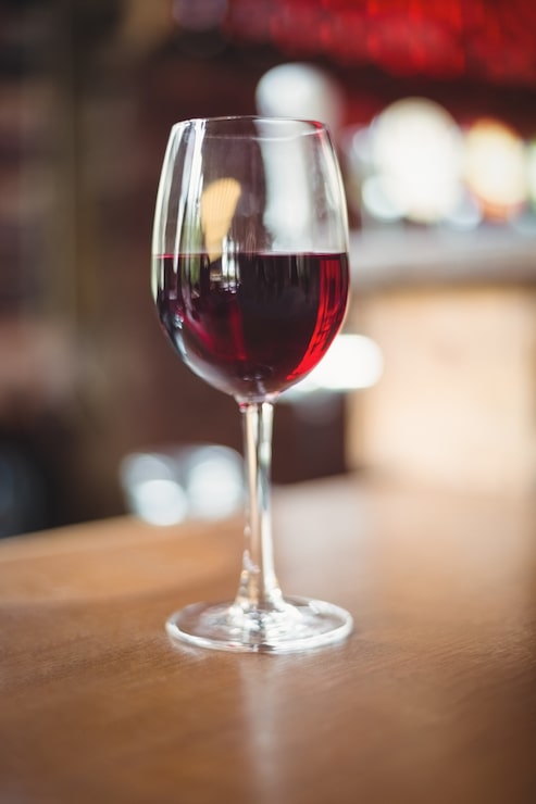 Foto grátis close-up de vidro com vinho tinto na mesa
