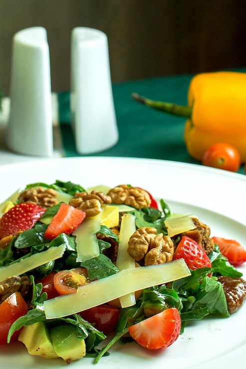 Foto grátis close-up vista de salada fresca com queijo parmesão nozes abacate tomate cereja e morangos em uma tigela branca