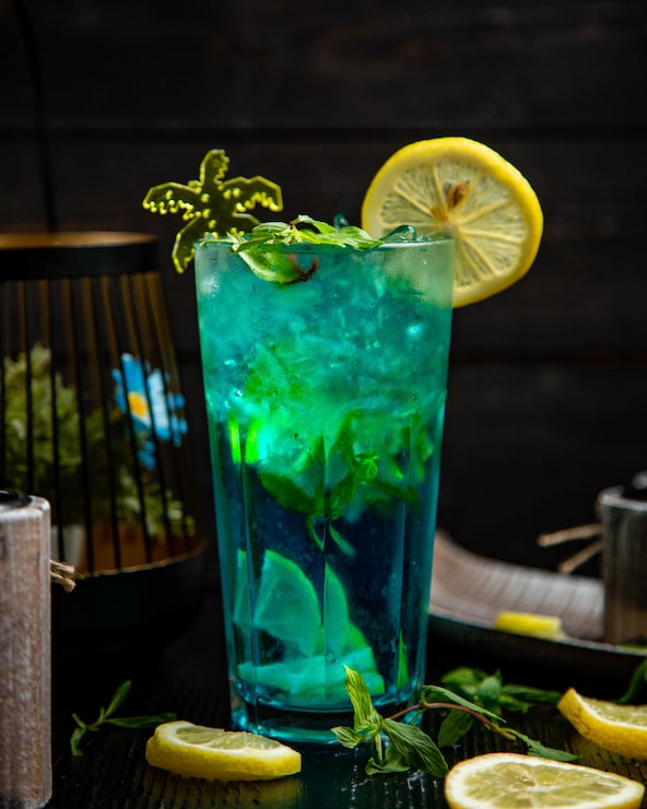 Foto grátis cocktail azul com hortelã e limão em um copo.