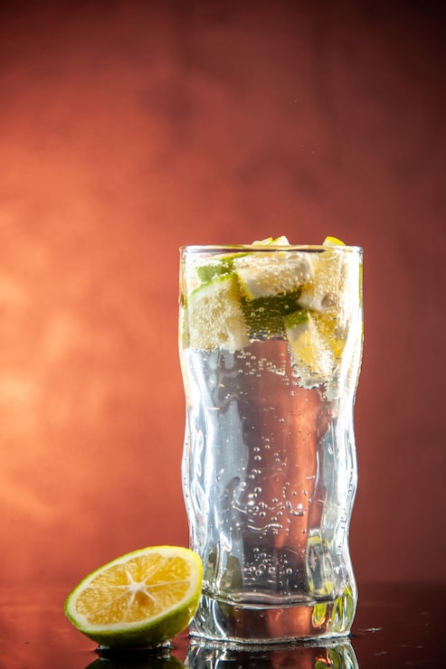 Foto grátis copo de refrigerante com rodelas de limão na foto rosa claro champanhe água coquetel bebida limonada