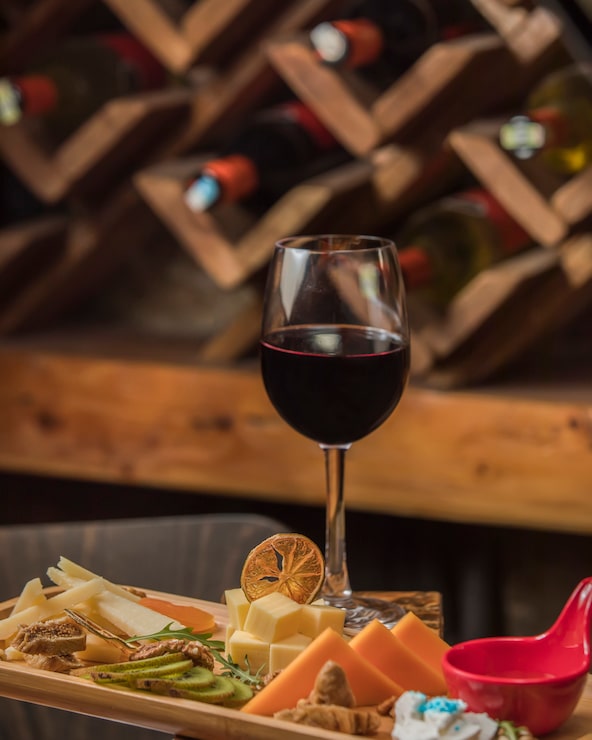 Foto grátis copo de vinho tinto, servido com prato de queijo
