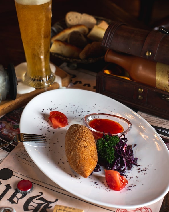 Foto grátis costeleta de kiev de frango servida com salada de repolho, verduras, molho e fatias de tomate
