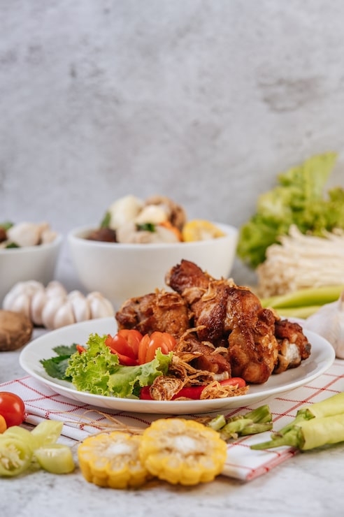 Foto grátis coxa de frango frito com tomate, pimenta, cebola frita, alface, milho e cogumelo de agulha.