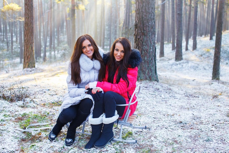 Foto grátis dois amigos alegres vão sentar-se em cadeiras na floresta no inverno