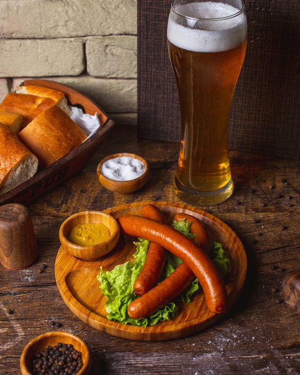 Foto grátis enchidos servidos com alface, mostarda e cerveja
