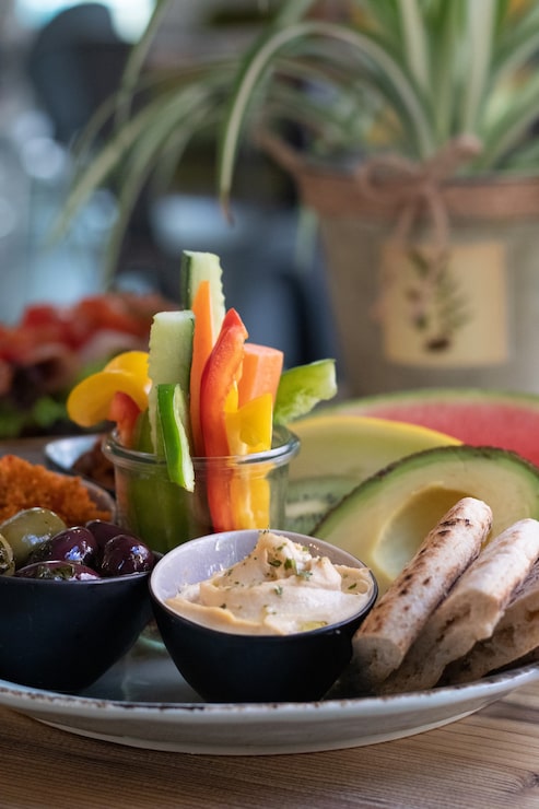 Foto grátis foto vertical de um prato de comida tradicional etíope, frutas e vegetais em uma mesa de madeira