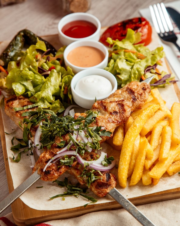 Foto grátis frango lula batatas fritas salada vista lateral