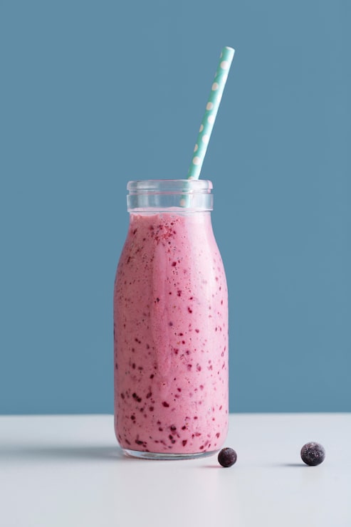 Foto grátis garrafa de smoothie rosa vista frontal com palha e mirtilos