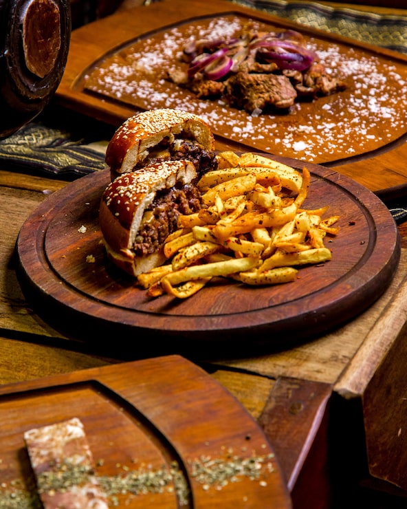 Foto grátis hambúrguer de carne com batatas fritas vista lateral