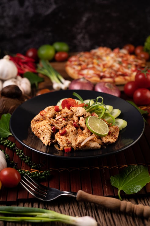Foto grátis larva de frango no prato com pimenta-malagueta seca, tomate, cebolinha e alface