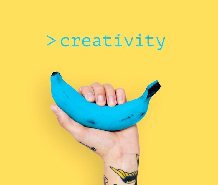 Foto grátis mão com tatuagem levantando banana azul com fundo amarelo