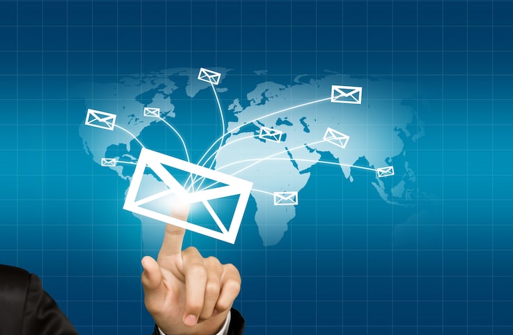Foto grátis mão pressionando um envelope que é enviado para o mundo