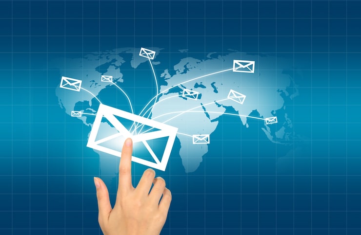 Foto grátis mão pressionando um envelope que é enviado para o mundo