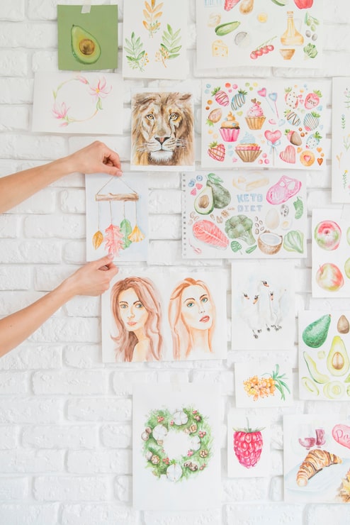 Foto grátis mãos colocando desenhos na parede