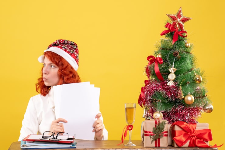 Foto grátis médica com vista frontal segurando documentos e sentada com presentes de natal