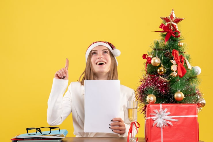 Foto grátis médica vista frontal sentada com presentes de natal segurando documentos no fundo amarelo
