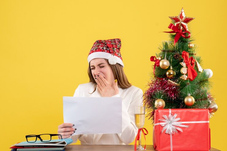 Foto grátis médica vista frontal sentada com presentes de natal segurando documentos no fundo amarelo