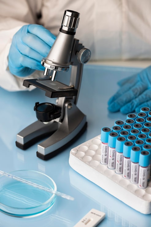 Foto grátis médico analisando amostras de sangue com um microscópio