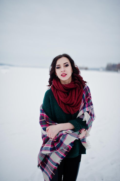 Foto grátis menina morena de suéter verde e cachecol vermelho com lago congelado ao ar livre na noite de inverno