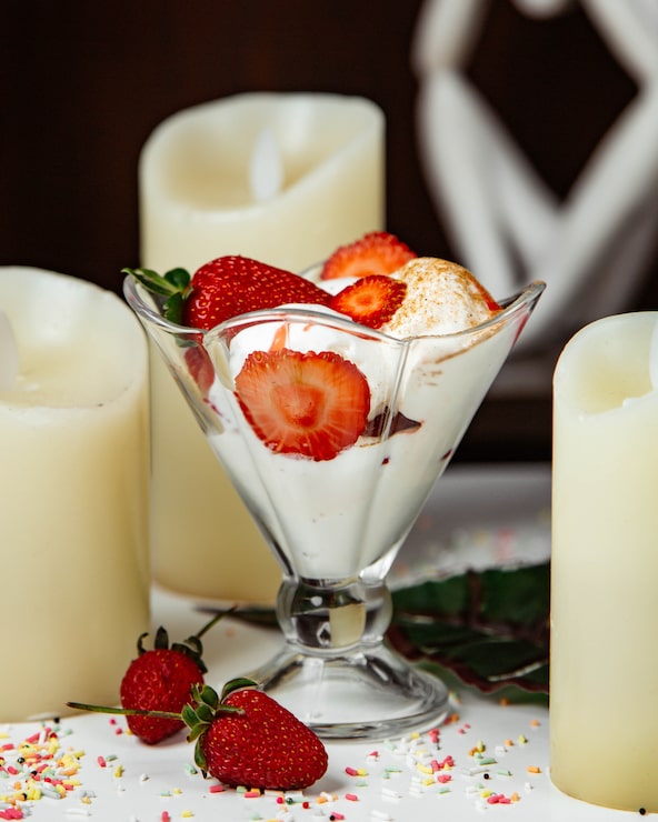 Foto grátis mousse de creme com morangos em volta das velas.