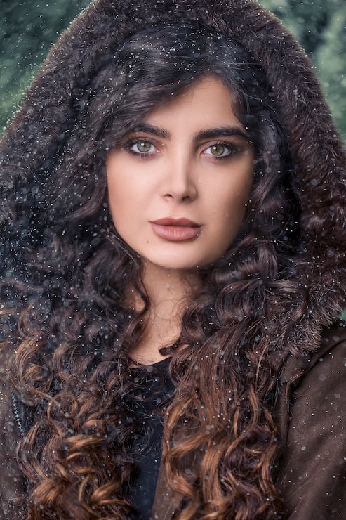 Foto grátis mulher de cabelo encaracolado com capuz de pele