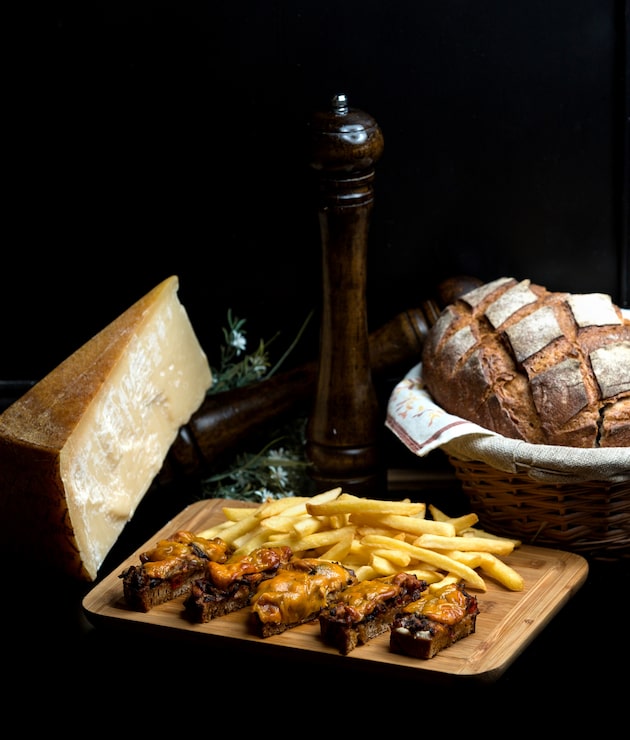 Foto grátis pão preto frito com cebola e carne coberto com queijo ralado