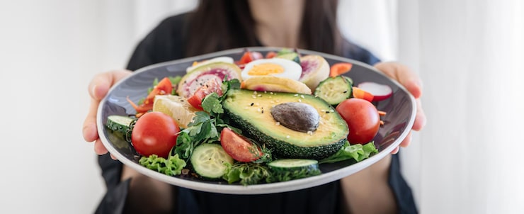Foto grátis salada apetitosa com legumes frescos e ovos num prato em mãos femininas