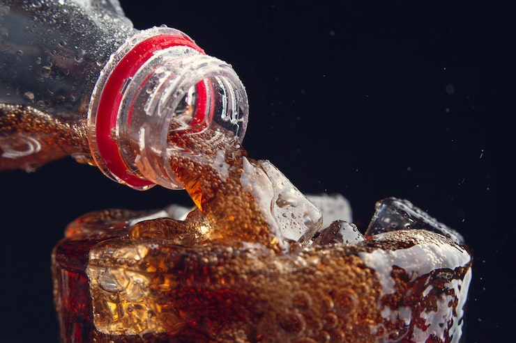 Foto grátis servindo uma cola de uma garrafa para um copo cheio de gelo