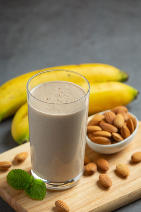 Foto grátis smoothie de banana e amêndoa em fundo escuro
