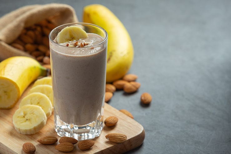 Foto grátis smoothie de banana e amêndoa em fundo escuro