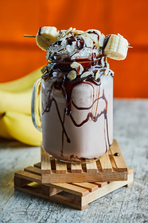 Foto grátis smoothie de chocolate com xarope de chocolate e ramo de banana