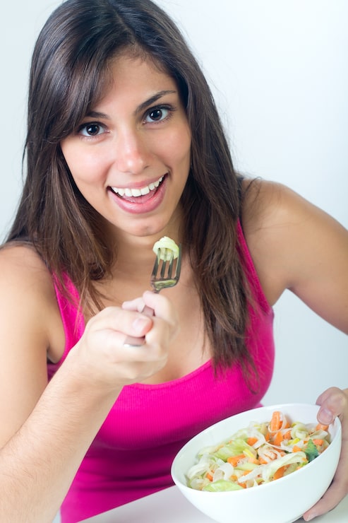 Foto grátis studio portrait of beautiful young woman eating