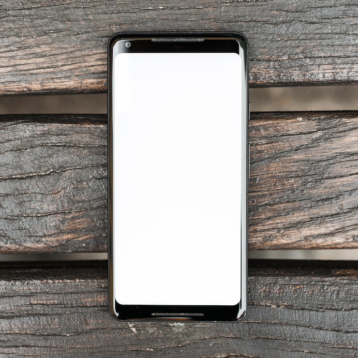 Foto grátis telemóvel com ecrã branco na prancha de madeira texturizada