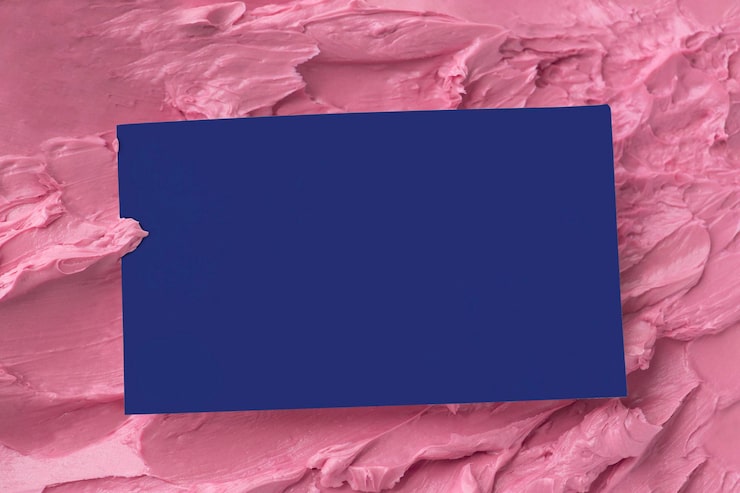 Kostenlose Foto blaue visitenkarte auf rosa zuckerguss-textur