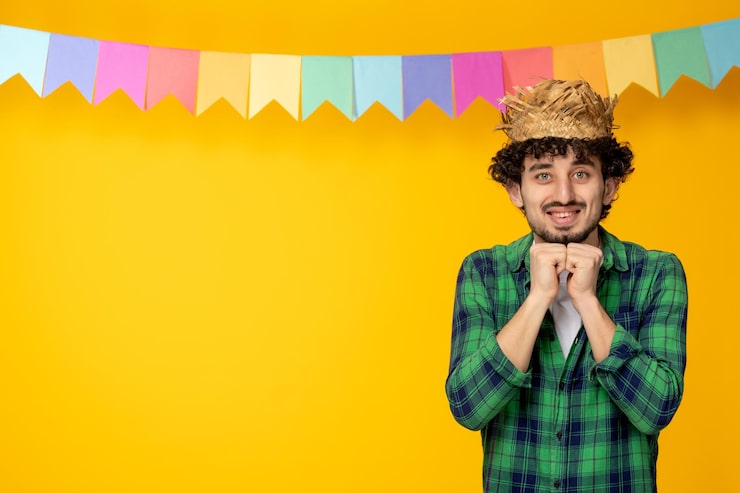 Kostenlose Foto festa junina junger süßer kerl mit strohhut und bunten flaggen brasilianisches festival aufgeregt