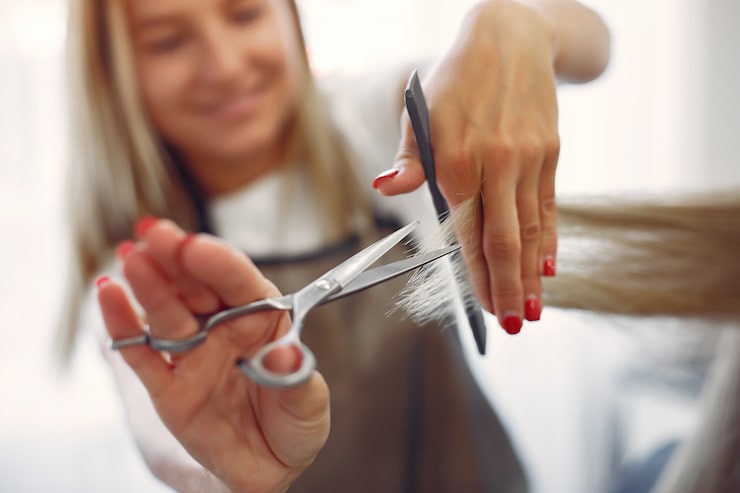 Kostenlose Foto friseurin schneidet ihren kunden in einem friseursalon die haare