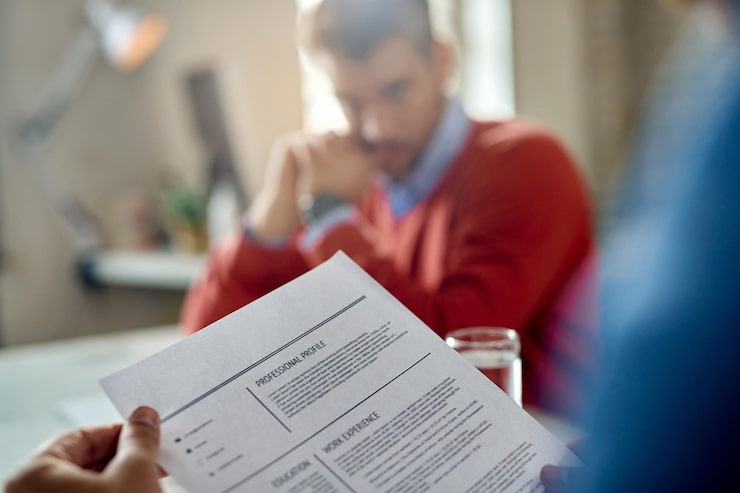 Kostenlose Foto nahaufnahme eines mitarbeiters der personalabteilung, der den lebenslauf des kandidaten während des meetings im büro liest