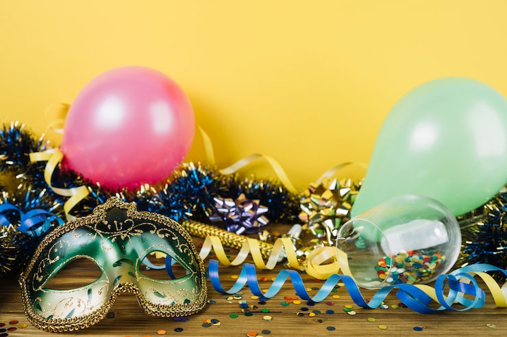 Kostenlose Foto partydekorationsmaterial mit maskeradekarnevalsfedermaske und -ballonen auf holztisch