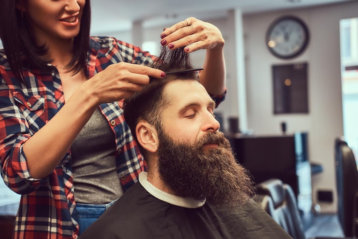 Kostenlose Foto professioneller friseur, der frisur mit einem kamm in einem friseursalon herstellt.