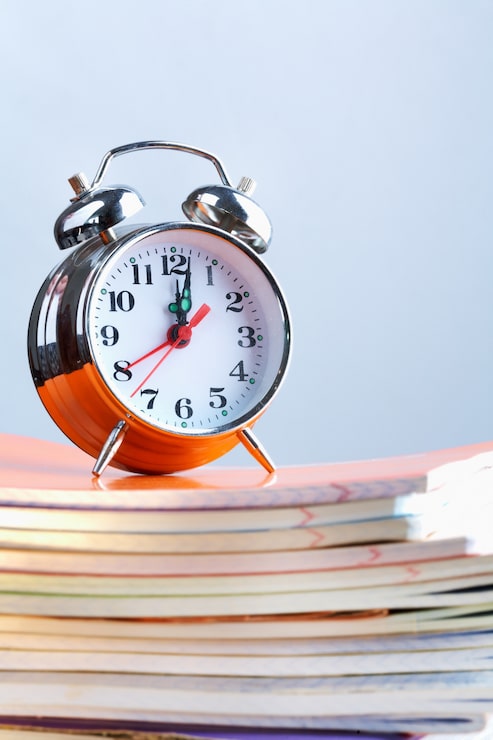 Kostenlose Foto uhr auf einem stapel von notebooks