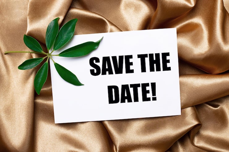 Foto auf wunderschön geschwungener goldener seide liegen ein schefflera-blatt und eine weiße karte mit dem text save the date