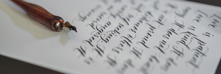 Foto banner langformatige kalligrafhände schreiben phrase auf weißem papier bibelphrase über liebe