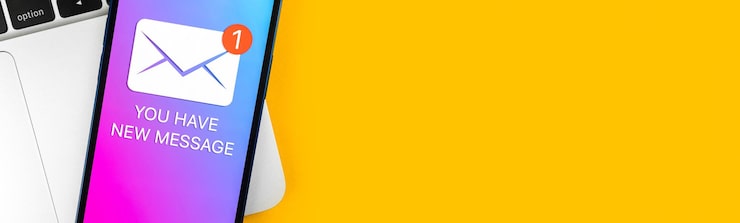 Foto banner você tem uma nova notificação de texto de mensagem em uma tela de telefone móvel vista de perto conceito de comunicação empresarial laptop e mesa de escritório foto de fundo