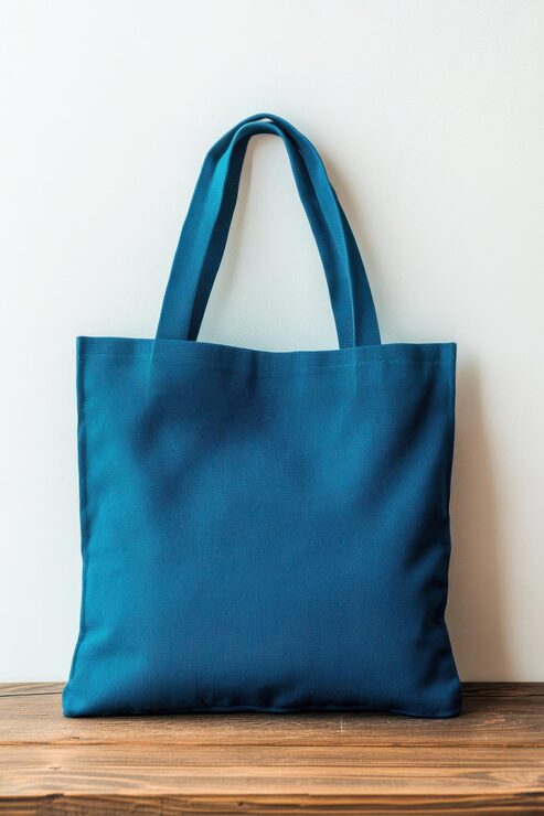 Foto bolsa de tela azul en superficie de madera contra un fondo blanco