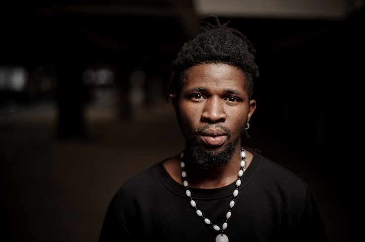 Foto chico afroamericano en ropa negra con rastas y barba