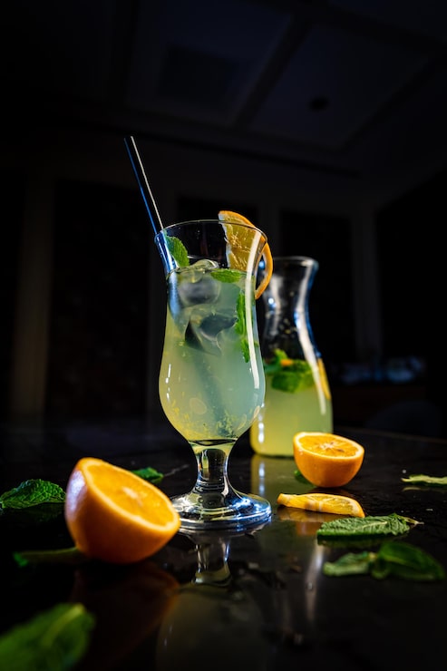 Foto una copa de cóctel de naranja y menta en una mesa