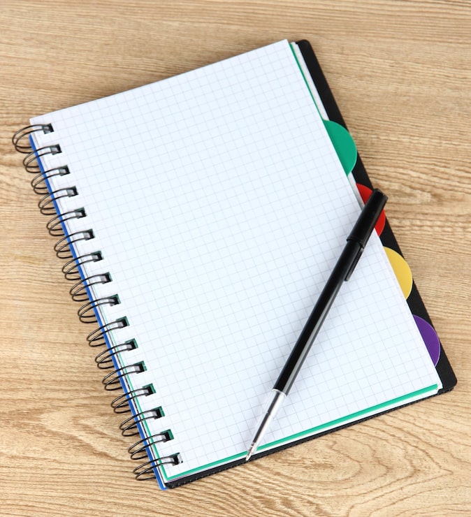 Foto cuaderno y pluma en la mesa de madera